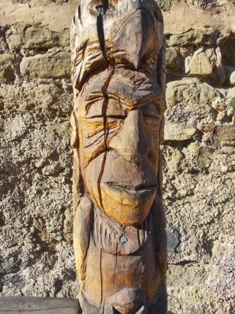 Totem handcrafted woodwork. Body shape. Smiling face. Carpentry  