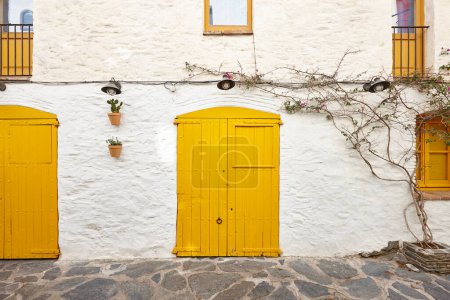 Photo for Picturesque yellow doors over a white facade. Cadaques, Girona. Spain - Royalty Free Image