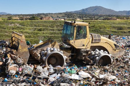 Schwere Maschinen schreddern Müll auf einer Deponie unter freiem Himmel. Verschwendung