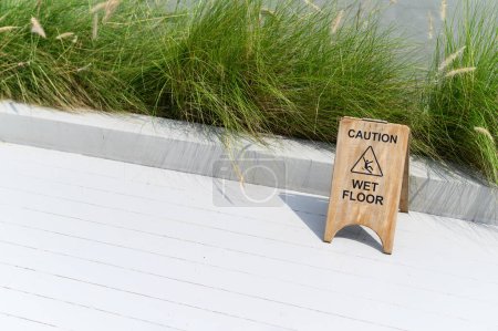 Photo for Wooden wet floor caution sign. - Royalty Free Image