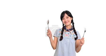Téléchargez les photos : Portrait beautiful young asian woman smile in denim dress with spoon and fork on white background - en image libre de droit
