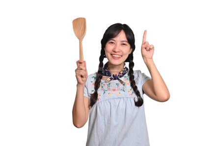 Photo for Portrait beautiful young asian woman smile in denim dress with spatula on white background - Royalty Free Image