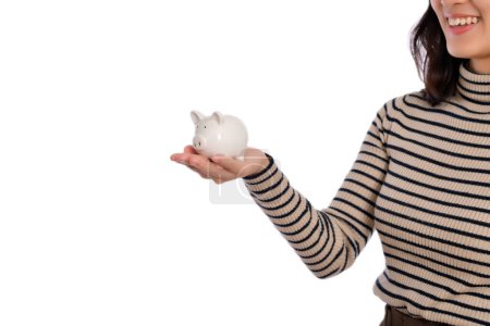 Foto de Retrato de una joven asiática sosteniendo alcancía blanca aislada sobre fondo blanco, concepto de ahorro financiero y bancario - Imagen libre de derechos