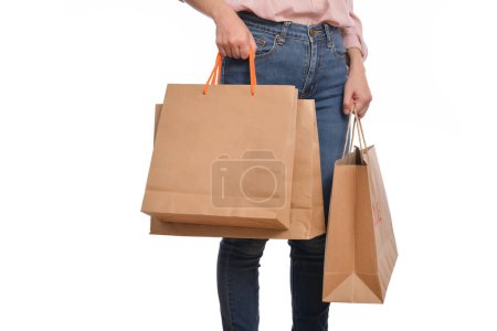 Foto de Primer plano de la mano de la mujer con ropa casual sosteniendo bolsa de papel de compras aislada sobre fondo blanco. - Imagen libre de derechos