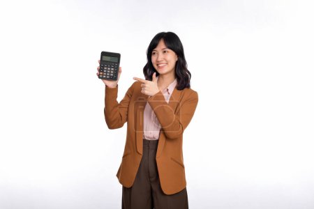 Téléchargez les photos : Tax day concept. Asian woman confident smiling holding calculator and finger point device, Portrait happy Asian female isolated on white background, Account and finance counting income. - en image libre de droit