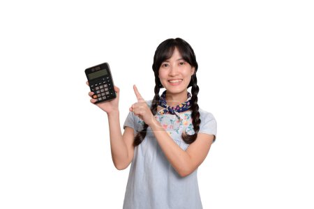 Foto de Portrait of beautiful happy young asian woman in denim dress holding calculator on white background. business shopping online concept. - Imagen libre de derechos