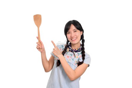 Foto de Portrait beautiful young asian woman smile in denim dress with spatula on white background - Imagen libre de derechos