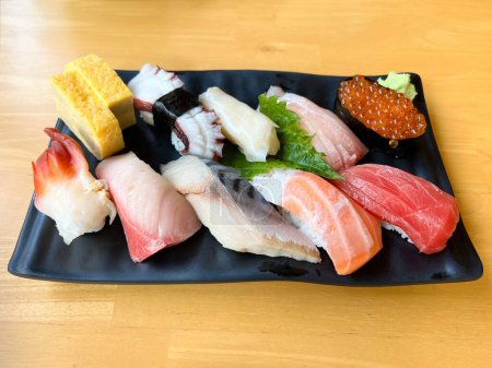 Foto de El lugar de juego de sushi premium en plato negro - Imagen libre de derechos