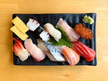 Foto de El lugar de juego de sushi premium en plato negro - Imagen libre de derechos