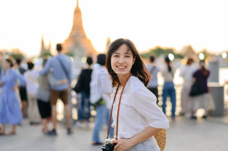 Téléchargez les photos : Portrait belle femme asiatique souriant tout en voyageant au point de vue du coucher du soleil Wat Arun, Bangkok, Thaïlande. - en image libre de droit