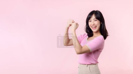 Téléchargez les photos : Portrait jeune femme asiatique confiante et fière montrant de forts bras de force musculaire fléchis posant, se sent sur sa réussite. Autonomisation des femmes, égalité, force saine et concept de courage - en image libre de droit