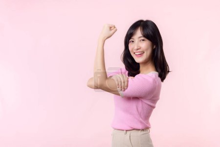 Téléchargez les photos : Portrait jeune femme asiatique confiante et fière montrant de forts bras de force musculaire fléchis posant, se sent sur sa réussite. Autonomisation des femmes, égalité, force saine et concept de courage - en image libre de droit