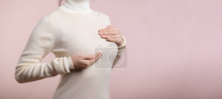 Photo for Woman hands checking lumps on her breast for signs of breast cancer on pink background. Healthcare concept. - Royalty Free Image