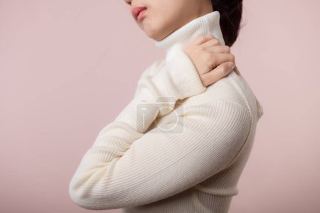 Foto de Joven asiática mujer sostener su mano en dolor cuello y lesión dolor hombro estrés problema muscular. Síndrome de oficina enfermedad, concepto de salud - Imagen libre de derechos