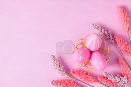 Photo for Happy Easter holiday greeting card concept. Colorful Easter Eggs and spring flowers on pastel pink background. Top view, flat lay, copy space. - Royalty Free Image