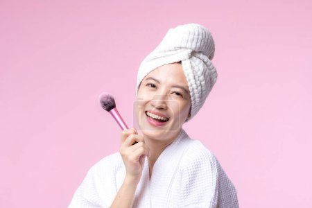 Photo for Portrait young happy asian woman with natural make up face holding cosmetic skin powder blusher isolated on pink background. Female apply skincare brush treatment. beauty product, cosmetology concept. - Royalty Free Image