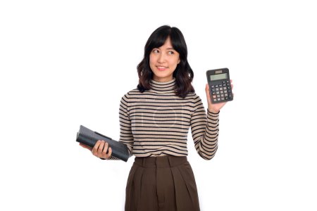 Foto de Joven mujer asiática uniforme casual sosteniendo alcancía blanca y portátil aislado sobre fondo blanco. Concepto de ahorro financiero y bancario - Imagen libre de derechos