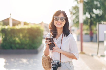 Téléchargez les photos : Portrait de jeune belle femme avec caméra explorer la rue à Bangkok, Thaïlande - en image libre de droit