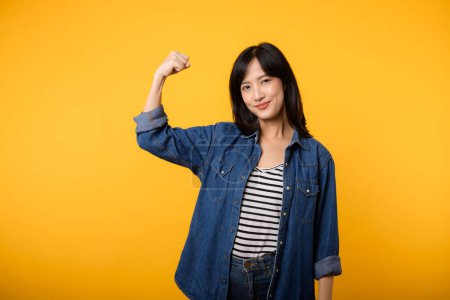 Foto de Retrato joven asiática mujer orgullosa y confiada mostrando fuerte fuerza muscular brazos flexionado posando, se siente acerca de su éxito logro. Empoderamiento de las mujeres, igualdad, fuerza saludable y concepto de valentía - Imagen libre de derechos