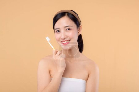 Photo for Portrait young beauty woman with healthy happy smile holding toothbrush in her hand at morning isolated on beige studio background. hygiene tooth mouth clean care and dental concept. - Royalty Free Image