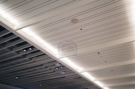 Téléchargez les photos : Lumières intérieures modernes plafond blanc fond de construction de conception. Lampe LED plafond intérieur salle de bureau dans le bâtiment de hall d'architecture. - en image libre de droit