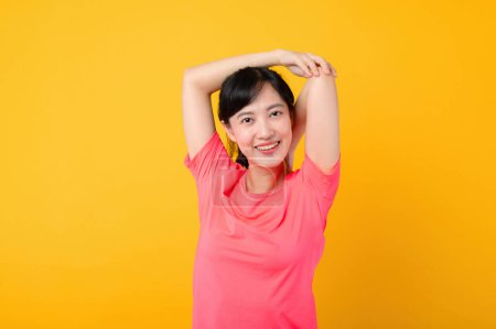 Photo for Portrait young beautiful asian sports fitness woman happy smile wearing pink sportswear posing exercise training workout isolated on yellow studio background. wellbeing and healthy lifestyle concept. - Royalty Free Image