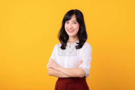 Téléchargez les photos : Portrait belle jeune femme asiatique enterpriser heureux sourire habillé en chemise blanche et plantes rouges montrant geste de pensée isolé sur fond studio jaune. - en image libre de droit