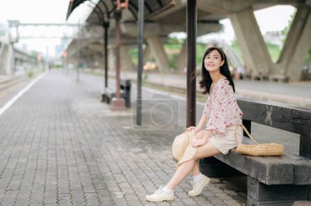 Foto de Asiático joven viajero con tejer cesta esperando tren en estación de tren. Viaje viaje estilo de vida, viajero mundial o concepto de turismo de verano de Asia. - Imagen libre de derechos