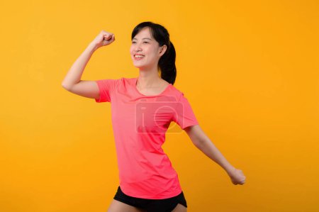 Photo for Portrait young beautiful asian sports fitness woman happy smile wearing pink sportswear posing exercise training workout isolated on yellow studio background. wellbeing and healthy lifestyle concept. - Royalty Free Image