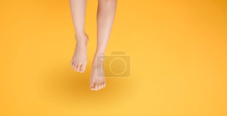 Photo for Capture the essence of smooth and soft touch with 30s elegant close up. Features woman's legs isolated on vibrant yellow background, conveying the concept of gentle and velvety foot touch. - Royalty Free Image