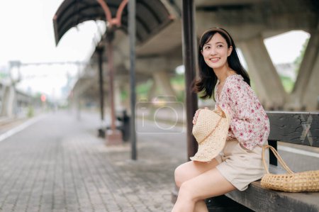 Foto de Asiático joven viajero con tejer cesta esperando tren en estación de tren. Viaje viaje estilo de vida, viajero mundial o concepto de turismo de verano de Asia. - Imagen libre de derechos
