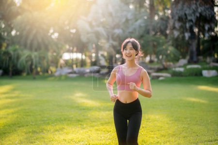 Téléchargez les photos : Joggeuse. forme jeune femme asiatique trentenaire en cours d'exécution dans le parc public au coucher du soleil. bien-être, activité à l'extérieur et concept de bien-être. - en image libre de droit