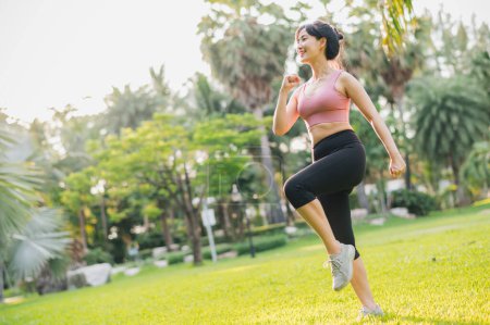 Téléchargez les photos : Bien-être et bien-être forme femme asiatique trentaine, port de vêtements de sport roses, l'exercice dans un parc public au coucher du soleil. Adoptez un mode de vie sain en plein air et découvrez les avantages du bien-être et du bien-être. - en image libre de droit