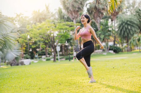 Téléchargez les photos : Concept de bien-être et de bien-être fit femme asiatique 30s portant des vêtements de sport roses faisant de l'exercice dans le parc public au coucher du soleil. mode de vie sain en plein air, bien-être et bien-être. - en image libre de droit