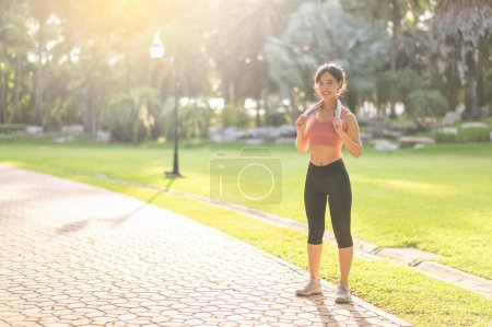 Photo for Witness the joy and serenity of a fit and happy young Asian woman 30s in sportswear, enjoying refreshing sunset run in nature. Experience the beauty and inspiration of fitness, health and motivation. - Royalty Free Image
