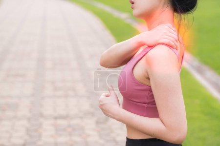 Téléchargez les photos : Joggeuse. 30s jeune asiatique femme portant rose vêtements de sport tenant son mal de dos après avoir couru exercice dans le parc public. Concept de douleur dans l'activité. - en image libre de droit