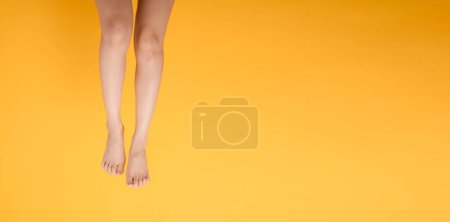 Téléchargez les photos : Capturez l'allure enchanteresse du toucher velouté des pieds avec le gros plan d'une personne des années 30 sur un fond jaune vif, évoquant l'élégance. - en image libre de droit