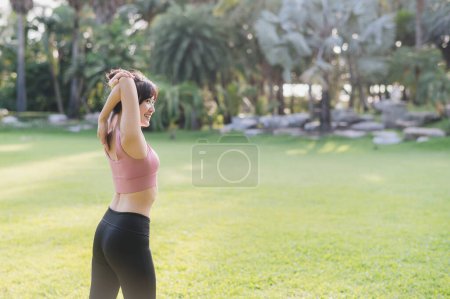 Photo for Embrace a wellness healthy lifestyle with back portrait of Asian 30s woman in pink sportswear, breathing fresh air and preparing body before running in public park at sunset. fitness outside concept - Royalty Free Image