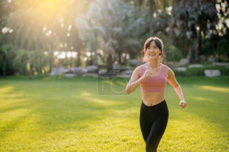 Foto de Una corredora. en forma joven mujer asiática de 30 años corriendo en el parque público al atardecer. bienestar, actividad exterior y concepto de bienestar. - Imagen libre de derechos