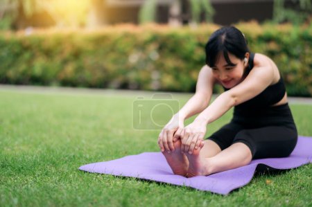 Téléchargez les photos : Portrait fit jeune femme asiatique en vêtements de sport rose avec tapis de yoga. étirement des muscles dans le parc. - en image libre de droit