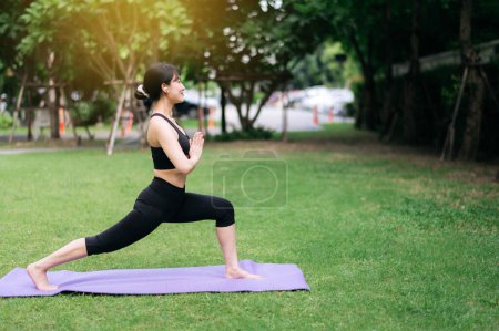 Téléchargez les photos : Portrait fit jeune femme asiatique en vêtements de sport rose. étirement des muscles dans le parc. Élevez votre santé et votre beauté grâce au yoga et à l'exercice. Découvrez l'harmonie intérieure parmi les verts des séances d'entraînement en plein air. - en image libre de droit