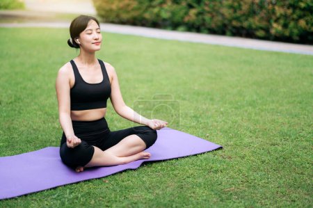 Photo for Serene yoga practice. young woman in sportswear meditating amidst lush greenery. Health, balance, and nature's embrace. - Royalty Free Image