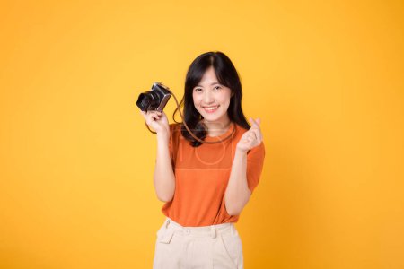 Téléchargez les photos : Jeune femme avec un sourire joyeux, tenant un appareil photo pour son voyage passionnant de vacances. - en image libre de droit