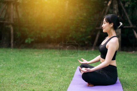 Foto de Green Wellness Haven. En medio del abrazo de la selva, la mujer en sus 30 años entusiasta del yoga disfruta de la meditación serena y poses vigorizantes. - Imagen libre de derechos