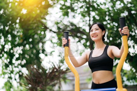 Photo for Young asian athletic sportswoman wearing sportswear listening relaxing music while working out exercise equipment outdoor in park. Healthy lifestyle concept - Royalty Free Image