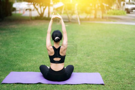 Téléchargez les photos : Portrait fit jeune femme asiatique des années 30 en vêtements de sport rose avec tapis de yoga. étirement des muscles dans le parc. Découvrez la beauté de la forme physique holistique. Joignez-vous pratiques féminines yoga au milieu de la nature embrasser. - en image libre de droit