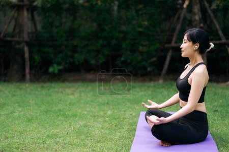 Photo for Forest Yoga Flow. Amidst lush greens, asian woman 30s wearing sportswear blends nature and practice, embracing wellness, relaxation, and vitality. - Royalty Free Image