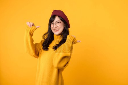 Photo for Join the promo fun with stylish woman, wearing a red beret and yellow sweater, as she points her thumb to free copy space against a vibrant yellow background. - Royalty Free Image