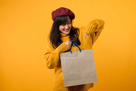 Téléchargez les photos : Vibes shopping week-end ! femme chic dans un béret rouge et pull jaune jouit de sa frénésie sur un fond jaune vibrant. - en image libre de droit