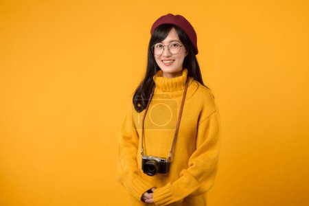 Una hacedora de recuerdos y fotógrafa, esta joven asiática, vestida con suéter amarillo y boina roja, captura momentos artísticamente con su cámara.